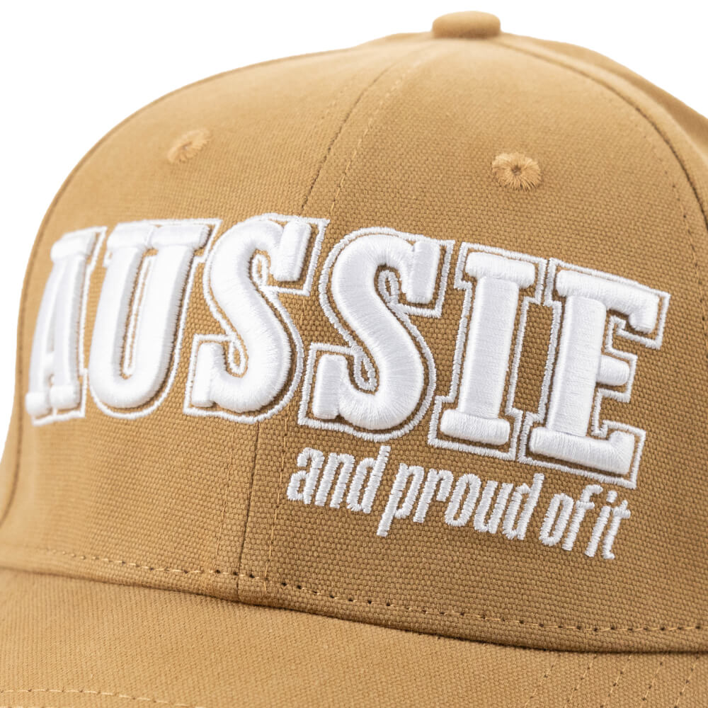 Close-up of the white “Aussie and proud of it” embroidery on the tan cap