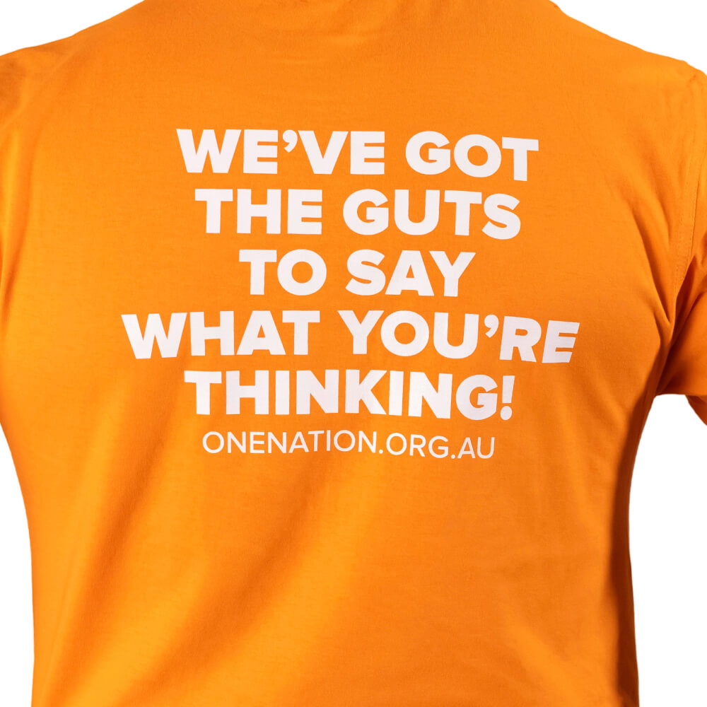 Close-up of the white “We’ve got the guts to say what you’re thinking!” print on the back of the orange T-shirt