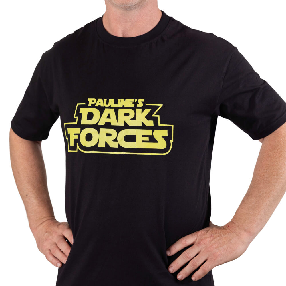 Man wearing the black “Pauline’s Dark Forces” T-shirt with yellow lettering